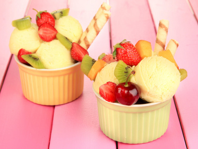 与水果和浆果在木桌上的碗中美味的冰淇淋
