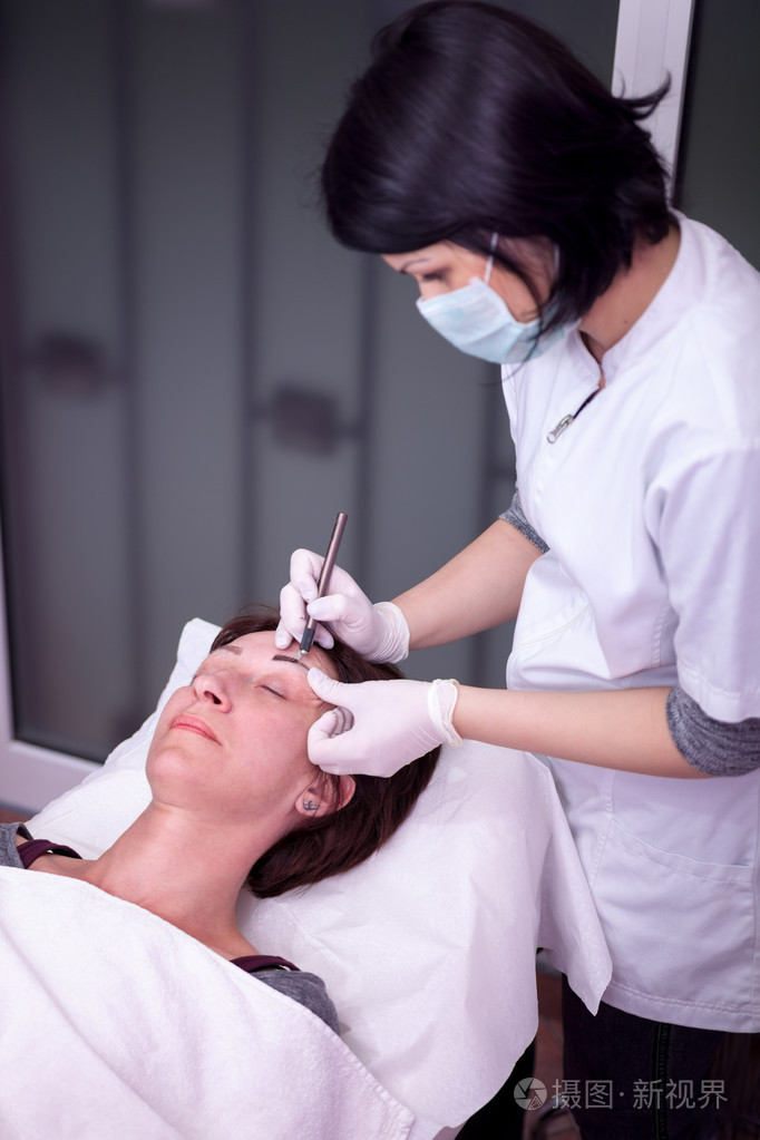 眉毛上弥补应用永久的美容师照片-正版商用图片0blcli-摄图新视界