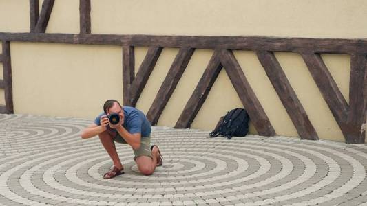 男摄影师在专业相机的帮助下在街上拍照。复制空间