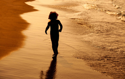 日落海滩上的儿童女孩剪影