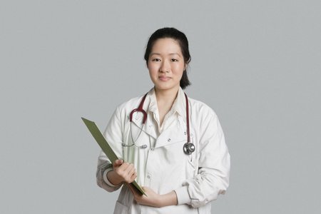 剪贴板缓缴的灰色背景亚洲女医生的肖像