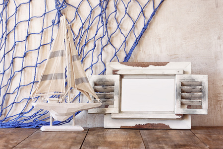 旧的老式木制白色框架和帆船木制的桌子上。老式的滤波的图像。航海生活方式的概念