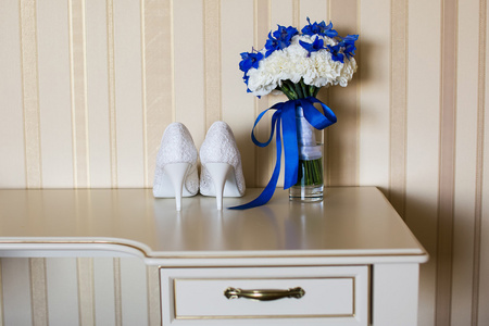 婚礼鞋和新娘的花束，用白色和蓝色的花朵