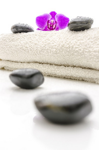 按摩的石头和一条毛巾上的紫兰花花