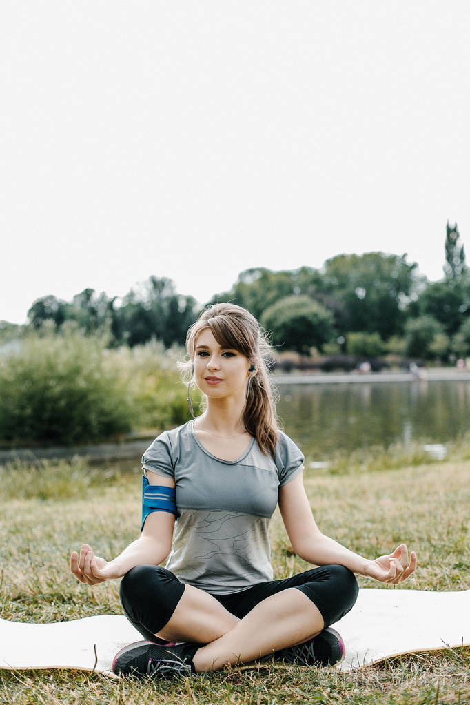 年轻的运动妇女在现代城市的楼梯上伸展腿.在大城市的健康生活方式.