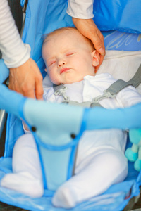 母亲的手抚摸头睡在婴儿推车婴儿