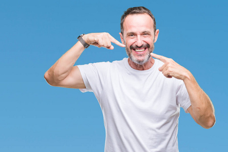 中年老人穿白色 t恤在孤立的背景微笑自信地显示和指着手指牙齿和嘴.