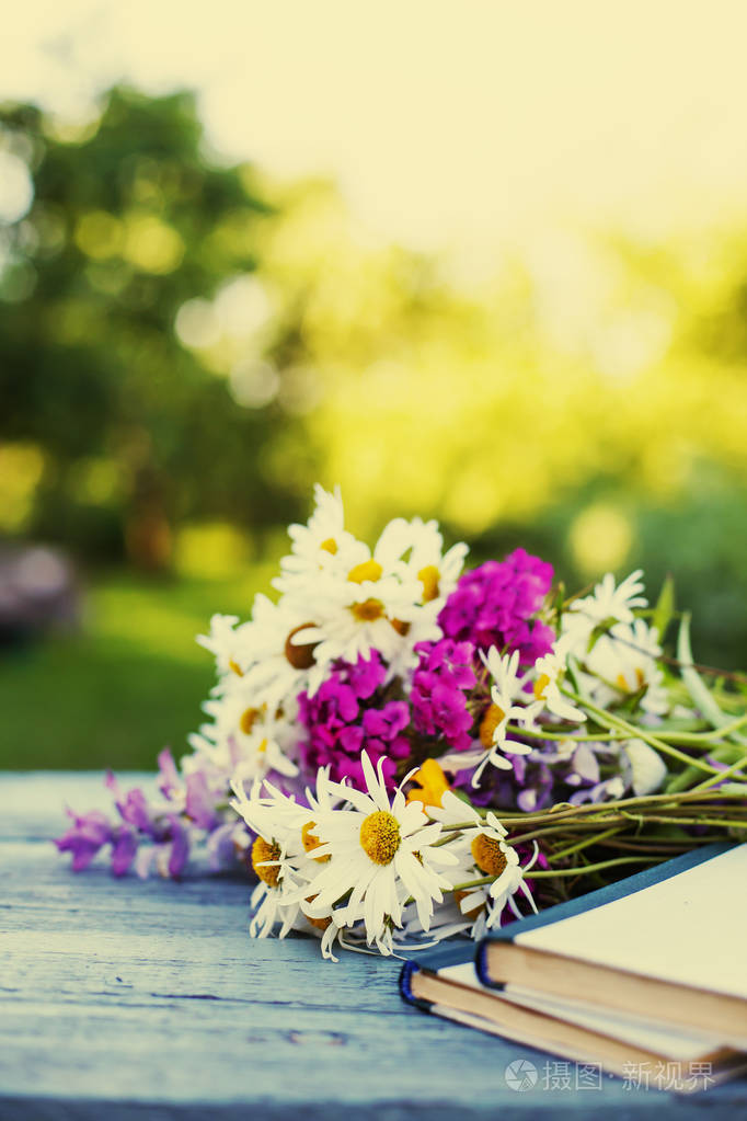 花的野花在破旧的木桌与复古书籍