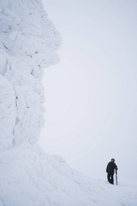 山上的岩石上有积雪和霜。严重的冬季远足。雪雾景观