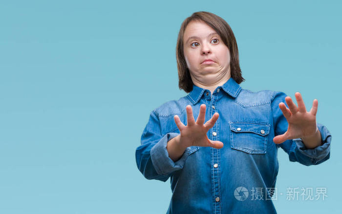 年轻的成年妇女与唐氏综合症在孤立的背景恐惧和惊恐的表达停止手势与