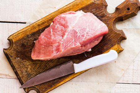 生猪肉在菜板上的刀
