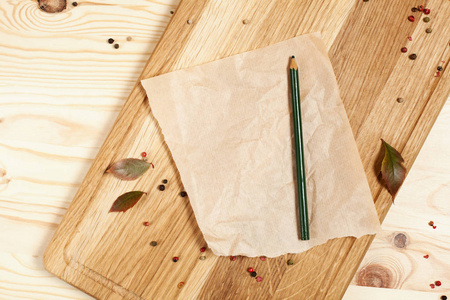 用一张纸和一支铅笔包围秋木背景上的木菜板留下一个地方为你题字