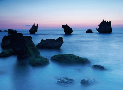 多姿多彩的夏天海景。在日落时的岩石海岸