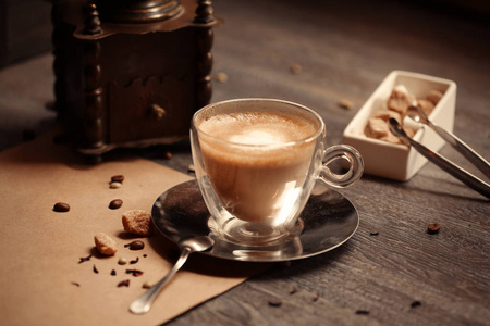 在咖啡店复古色调咖啡一杯。咖啡研磨器和棕色糖与 flare 木制的桌子上模糊背景。复古风格
