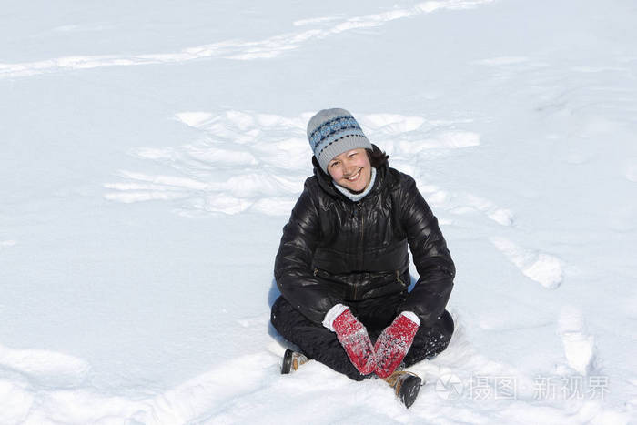 性格开朗微笑的女人蹲式盘腿在雪上