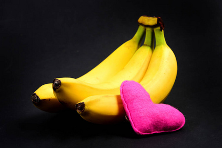心有粉红色和黑色背景上的三个香蕉