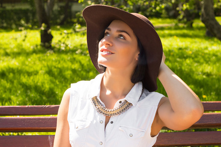 戴着帽子，在一个晴朗的日子公园吸引力微笑女人的画像