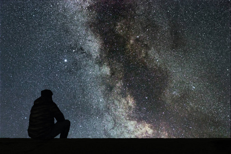 夜晚的天空,星星与剪影单独人看照片