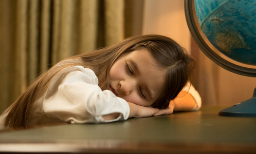 女生睡觉在桌子上睡觉的可爱累了女生的肖像照片