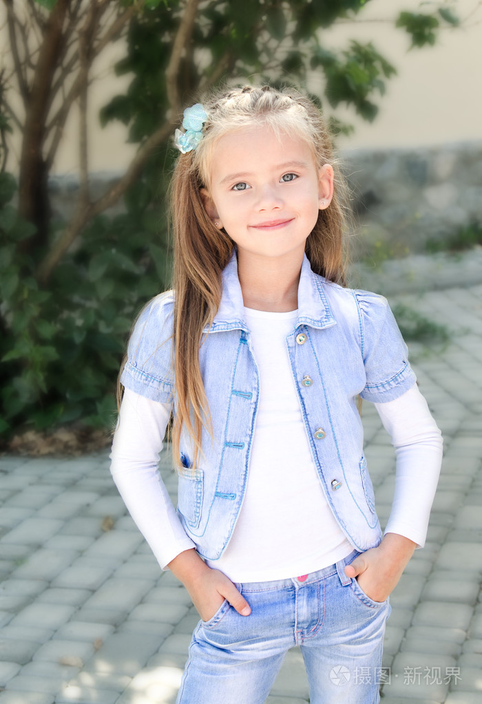 可爱微笑的小女孩在公园里的肖像