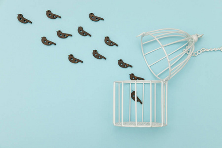 小鸟飞出了白色的笼子里照片