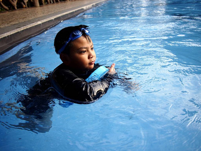 游泳和漂浮在游泳池里的小男孩