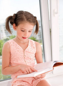 可爱的小女孩子正在读一本书
