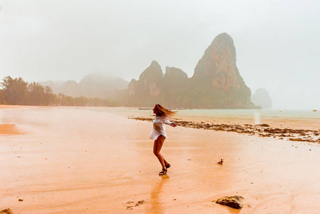 女人享受雨落泰国地处热带的海滩