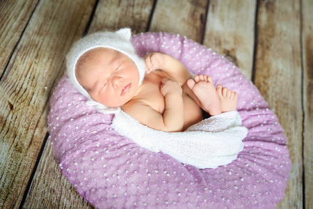 在紫罗兰色的枕头上睡着刚出生的婴儿