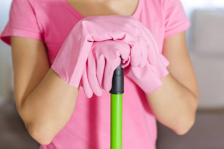 用湿拖把清洁地板时的防护手套的女人