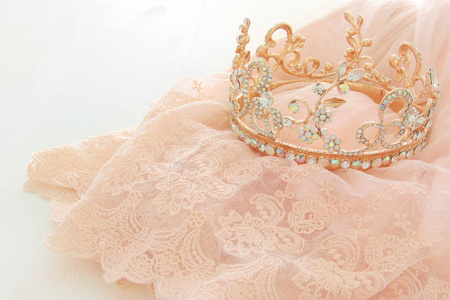 复古薄纱粉色纺礼服和钻石头饰白色木制的桌子上。婚礼和女孩的党理念