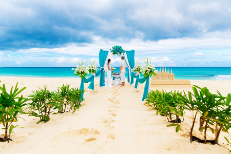 婚礼仪式在蓝色的热带海滩上。幸福的新郎和 br