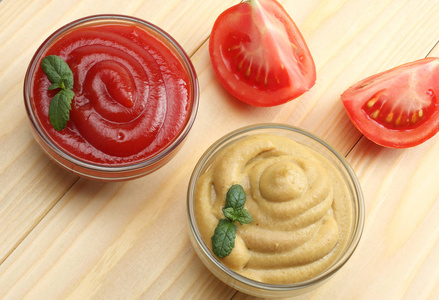 表芥末在玻璃碗里木背景上的芥末番茄酱.表照片