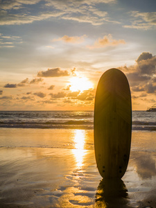 在日落时的海滩上的冲浪板