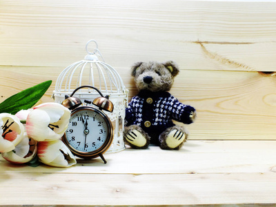 与闹钟和木制背景花束泰迪熊