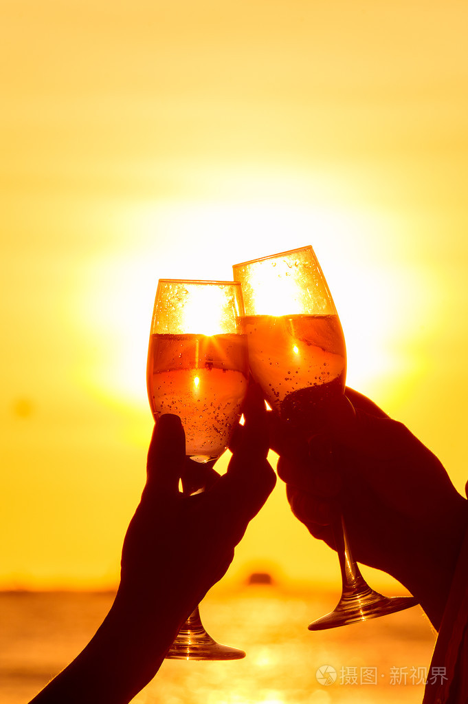 男人和女人在日落时叮叮当当酒杯香槟