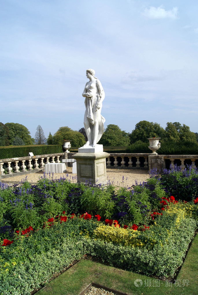 花园里的一座树桩上的女雕像