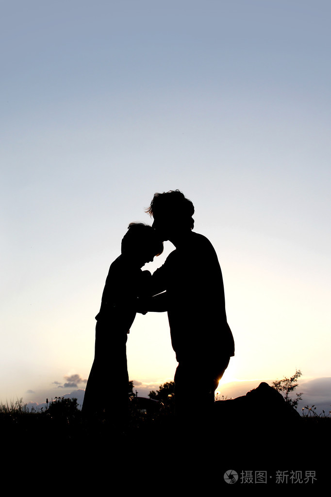 轮廓的额头上亲吻年轻孩子的父亲