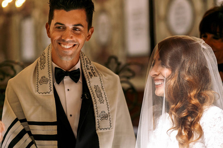 犹太的婚礼。美丽的新娘在新郎看起来