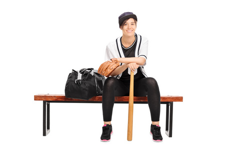 坐在长椅上的女棒球选手