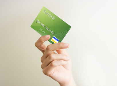 特写的绿色信用卡掌握手工