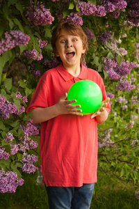 与单独在户外的丁香花公园玩游戏的绿色球运动快乐的微笑孩子男孩