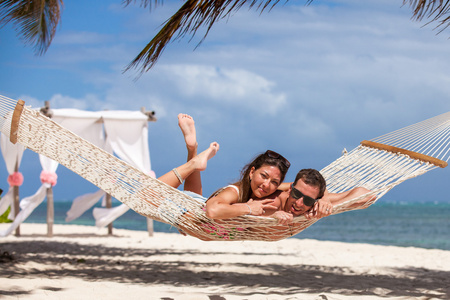浪漫情侣在海滩吊床放松