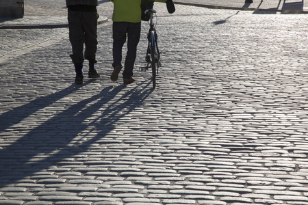 在斯德哥尔摩的鹅卵石街道上的行人和骑自行车的人