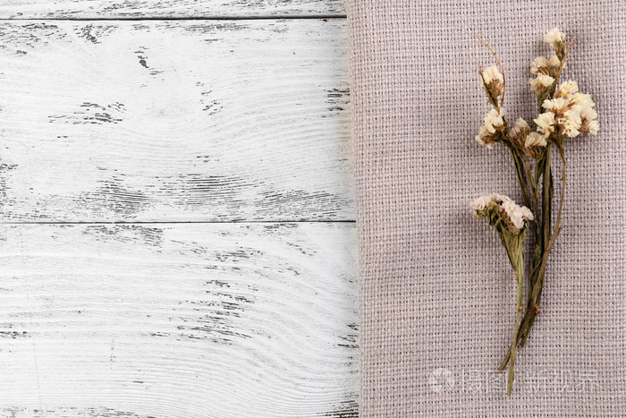美丽的干燥花在餐巾纸上木制的背景上照片 正版商用图片0bu28d 摄图新视界
