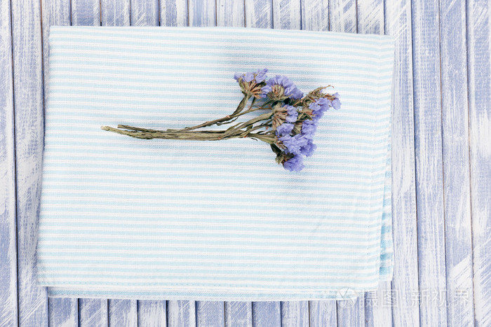 美丽的干燥花在餐巾纸上木制的背景上照片 正版商用图片0bu28e 摄图新视界