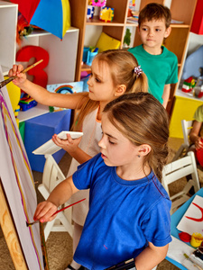 儿童绘画手指放在画架上。群与老师的孩子