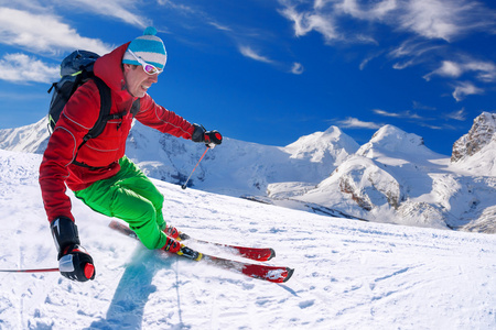 在蓝天的衬托高山滑雪的滑雪者