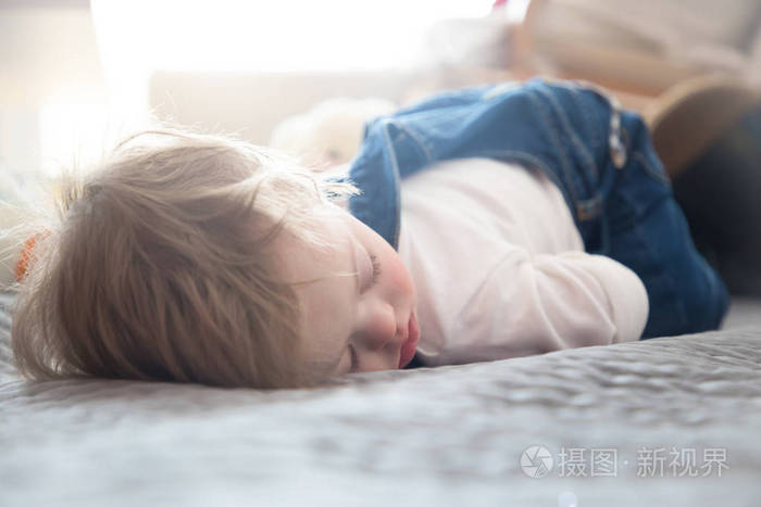 唐氏综合症患者在床上睡觉的可爱的小宝贝男孩
