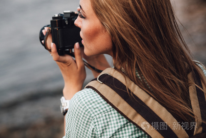 女孩用老式照片相机拍照
